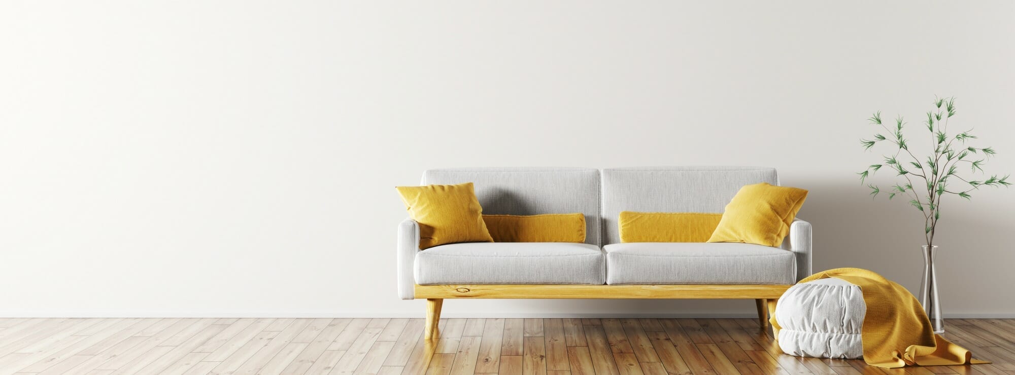 shutterstock_1049579273 bright room with wooden floors and a grey sofa with yellow pillows